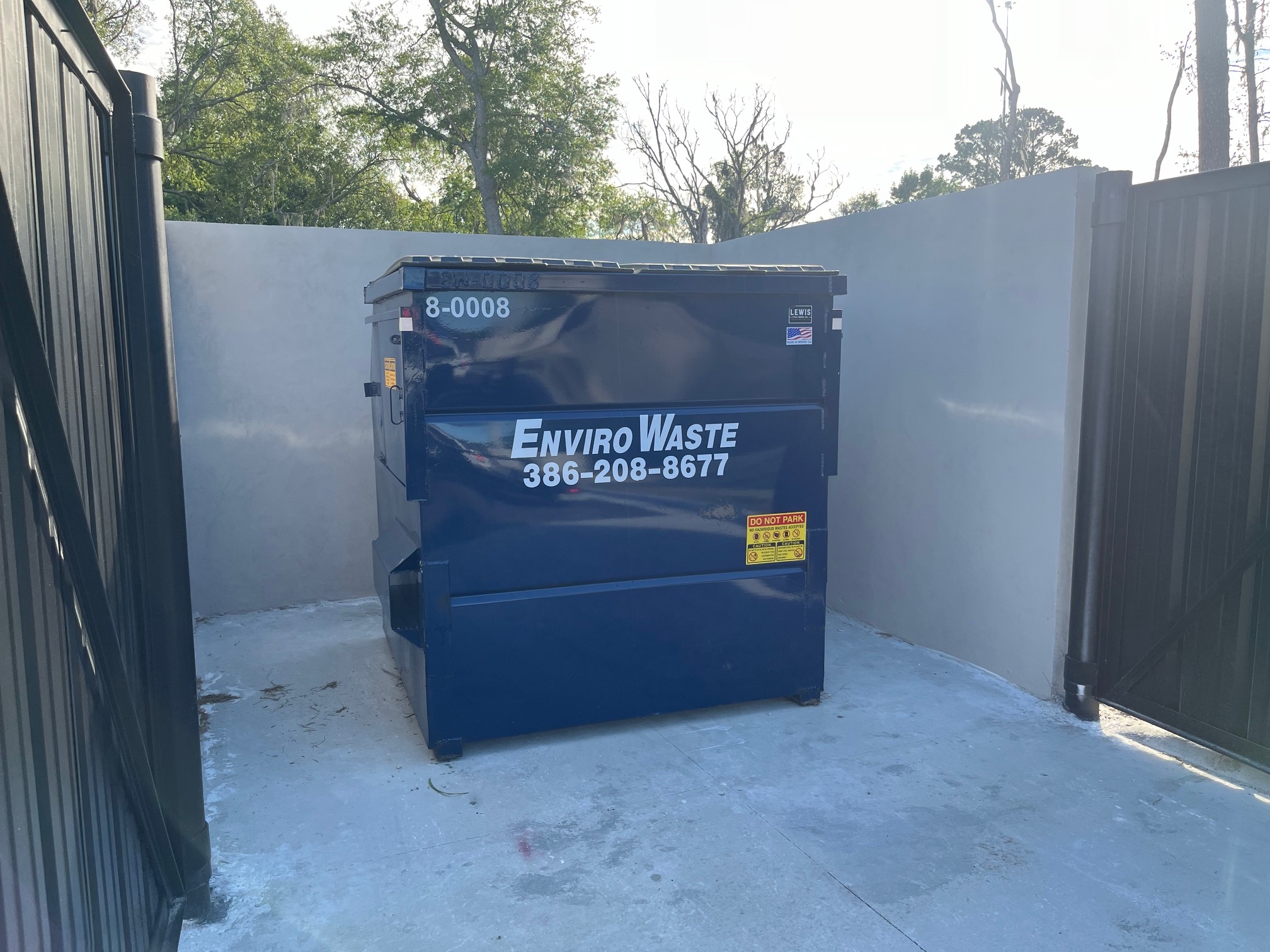 Envirowaste front-load dumpster ready for routine pickup at a North Florida business