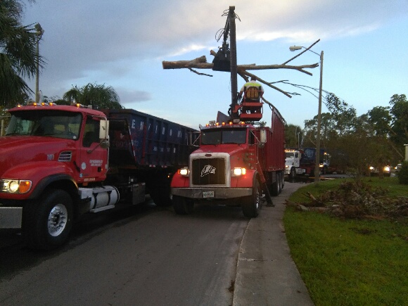 Envirowaste grapple truck loading storm debris and brush