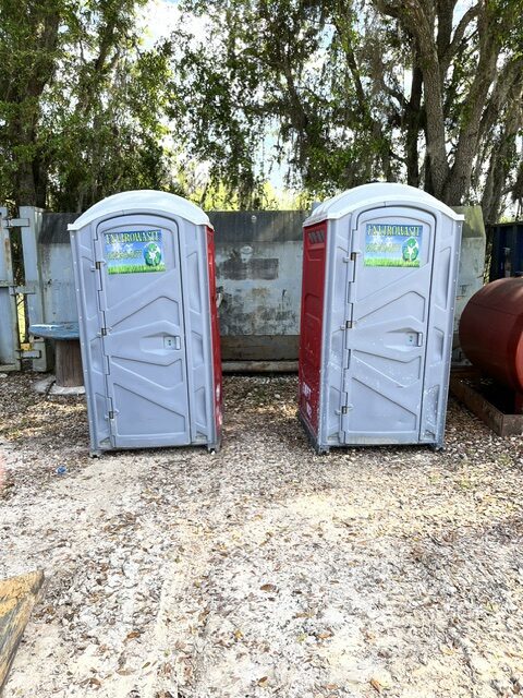 Row of three Envirowaste portable toilet units at a new housing development at midday