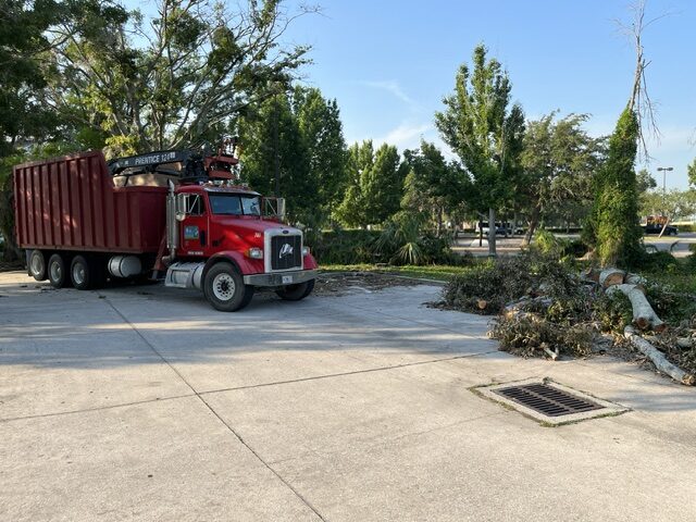 Envirowaste grapple truck hauling cleared debris off site